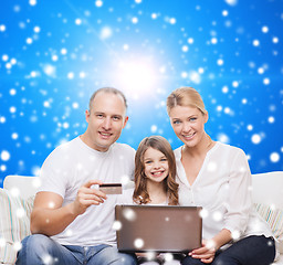 Image showing happy family with laptop computer and credit card