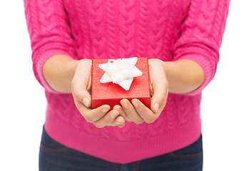 Image showing close up of woman in pink sweater holding gift box