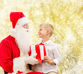 Image showing smiling little boy with santa claus and gifts