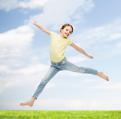 Image showing smiling little girl jumping