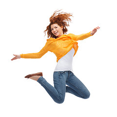 Image showing smiling young woman jumping in air