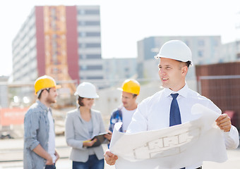 Image showing group of builders with tablet pc and blueprint