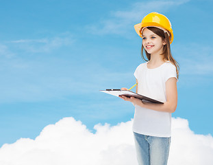 Image showing smiling little girl in hardhat with clipboard