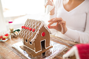 Image showing close up of woman making gingerbread houses