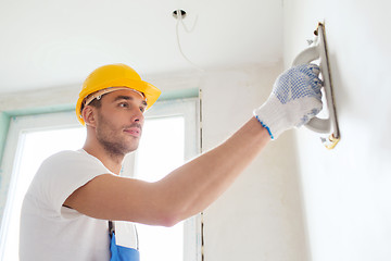 Image showing builder working with grinding tool indoors