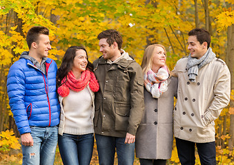 Image showing group of smiling men and women in autumn park