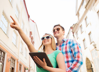 Image showing smiling couple with tablet pc in city