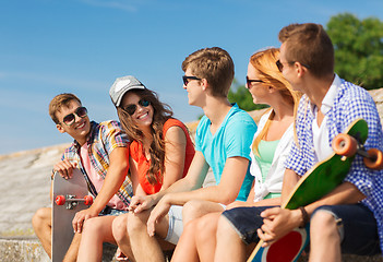 Image showing group of smiling friends sitting on city street