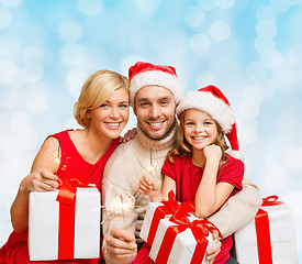 Image showing happy family in santa helper hats with gift boxes