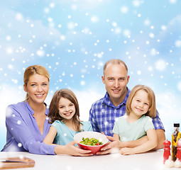 Image showing happy family with two kids showing salad in bowl
