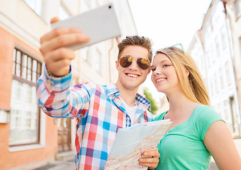 Image showing smiling couple with smartphone in city