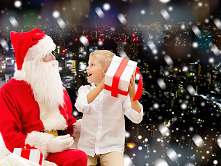 Image showing smiling little boy with santa claus and gifts