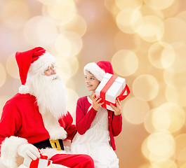 Image showing smiling little girl with santa claus and gifts