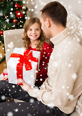 Image showing smiling father and daughter with gift box at home