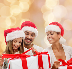 Image showing happy family in santa helper hats with gift boxes