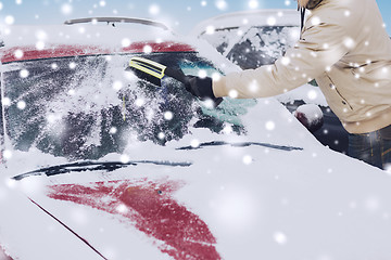 Image showing closeup of man cleaning snow from car