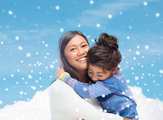 Image showing smiling little girl and mother hugging indoors