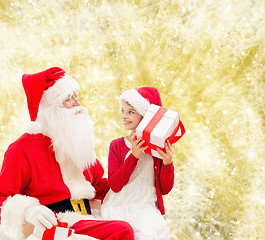 Image showing smiling little girl with santa claus and gifts