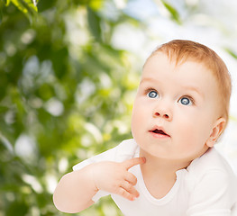 Image showing curious baby lying on floor and looking up