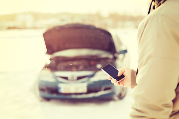 Image showing closeup of man with broken car and smartphone