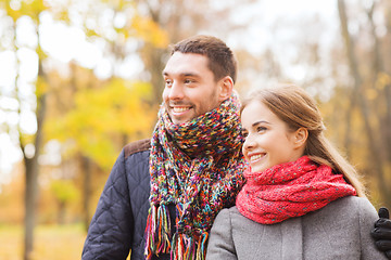 Image showing smiling couple hugging on bridge in autumn park