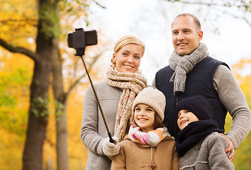 Image showing happy family with smartphone and monopod in park