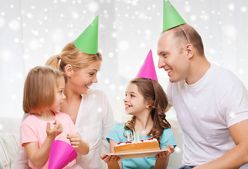 Image showing happy family with two kids in party hats at home