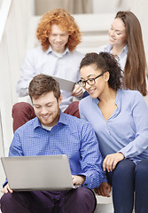 Image showing team with laptop and tablet pc on staircase