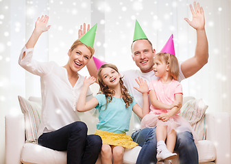 Image showing happy family with two kids in party hats at home