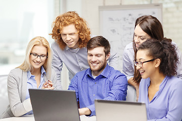 Image showing smiling team with laptop computers in office