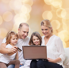 Image showing happy family with laptop computer and credit card