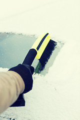 Image showing man cleaning snow from car windshield with brush