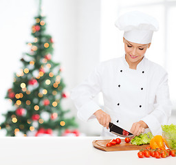 Image showing smiling female chef chopping vegetables