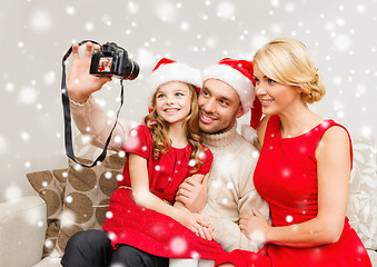 Image showing happy family with digital camera taking photo