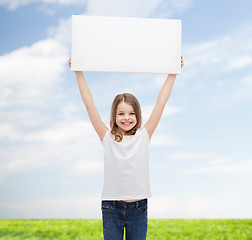 Image showing smiling little girl holding blank white board