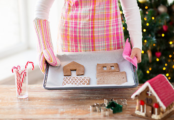 Image showing closeup of woman with gingerbread house on pan