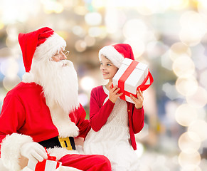 Image showing smiling little girl with santa claus and gifts