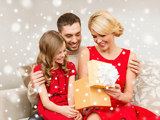 Image showing smiling family holding gift box