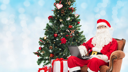 Image showing man in costume of santa claus with laptop