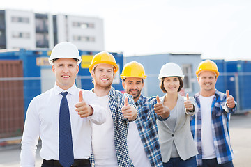 Image showing group of smiling builders in hardhats outdoors