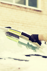 Image showing closeup of man cleaning snow from car