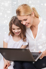 Image showing smiling mother and little girl with laptop at home