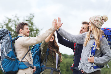 Image showing group of smiling friends with backpacks hiking