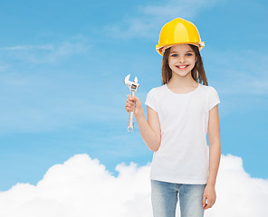 Image showing smiling little girl in hardhat with wrench