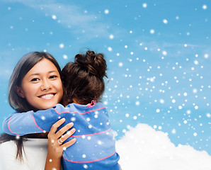 Image showing smiling little girl and mother hugging indoors