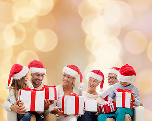 Image showing happy family in santa helper hats with gift boxes