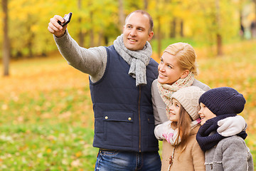 Image showing happy family with camera in autumn park