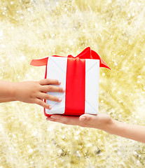 Image showing close up of child and mother hands with gift box