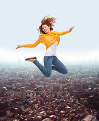 Image showing smiling young woman jumping high in air