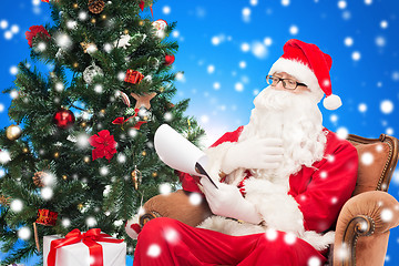 Image showing man in costume of santa claus with notepad